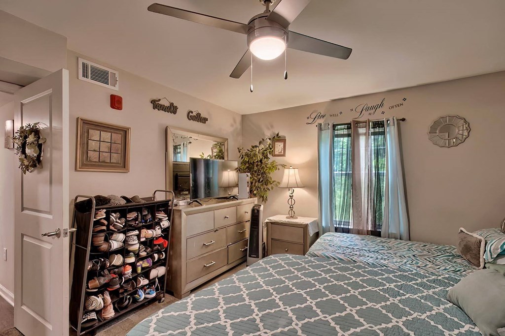 a bedroom with a large bed and a ceiling fan