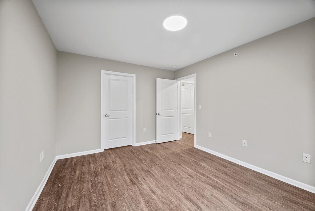 A room with a light brown floor and white walls.