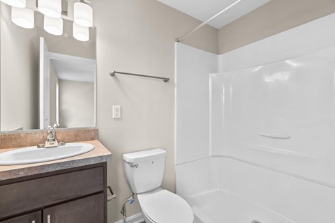 A white toilet sits next to a sink in a bathroom.