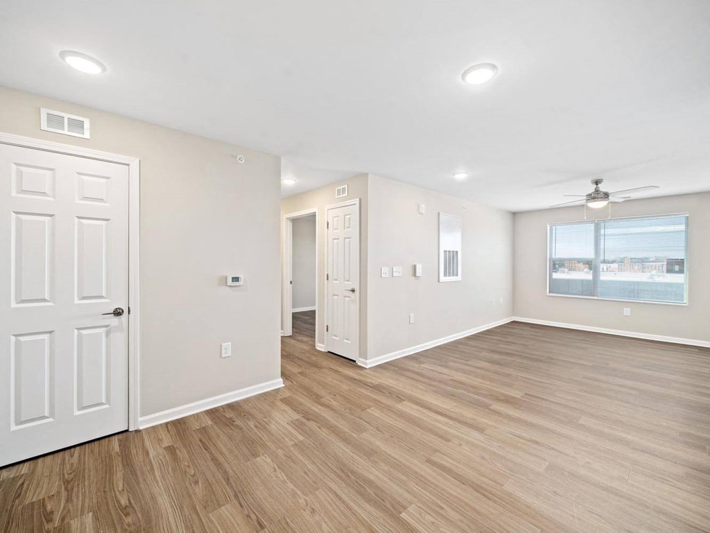 an empty living room with white walls and wood floors