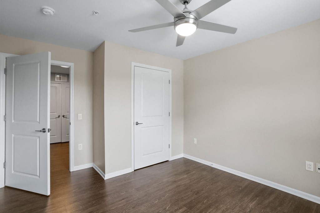 a bedroom with hardwood floors and a ceiling fan