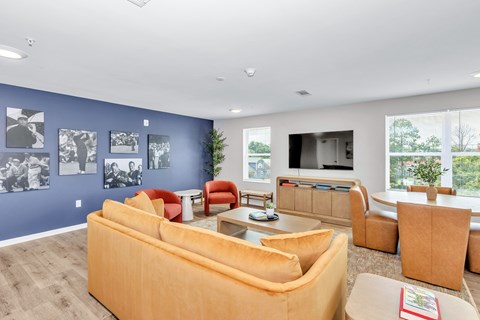 A living room with a yellow couch and a television.