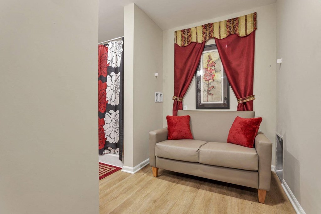 a living room with a couch and a window with curtains