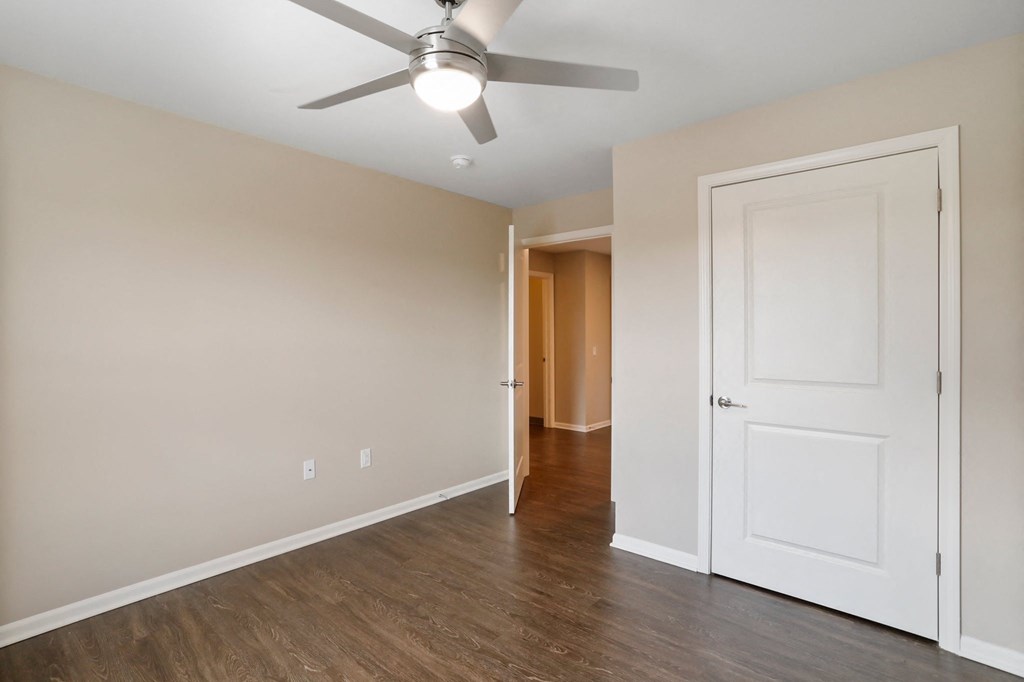 a bedroom with a ceiling fan and hardwood floors