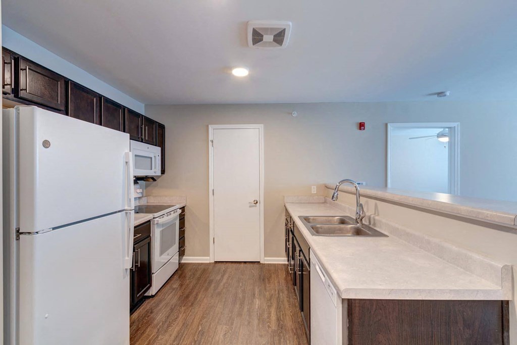 a kitchen with a white refrigerator freezer next to a stove top oven