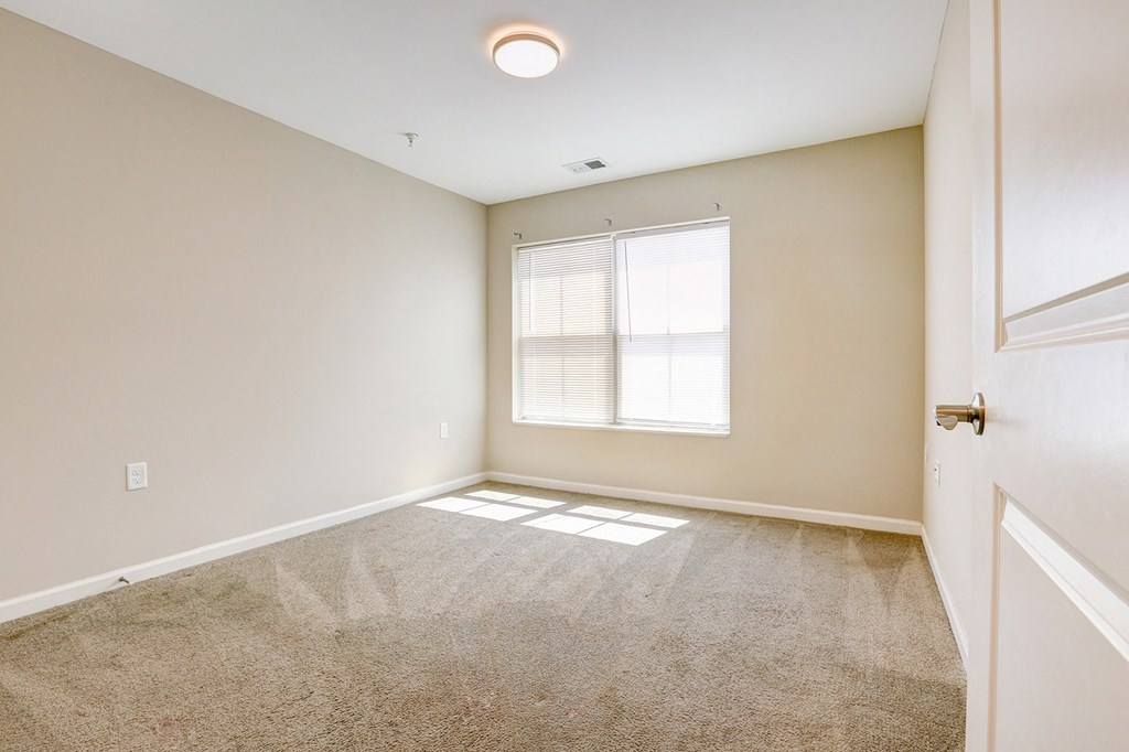 an empty room with a window and a door