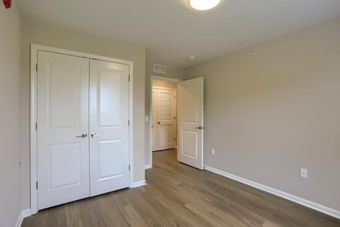 A room with two white doors and a wooden floor.