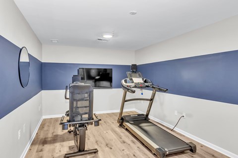 A treadmill and a stationary bike are in a room with blue walls.