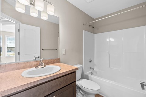 A bathroom with a sink, toilet, and bathtub.