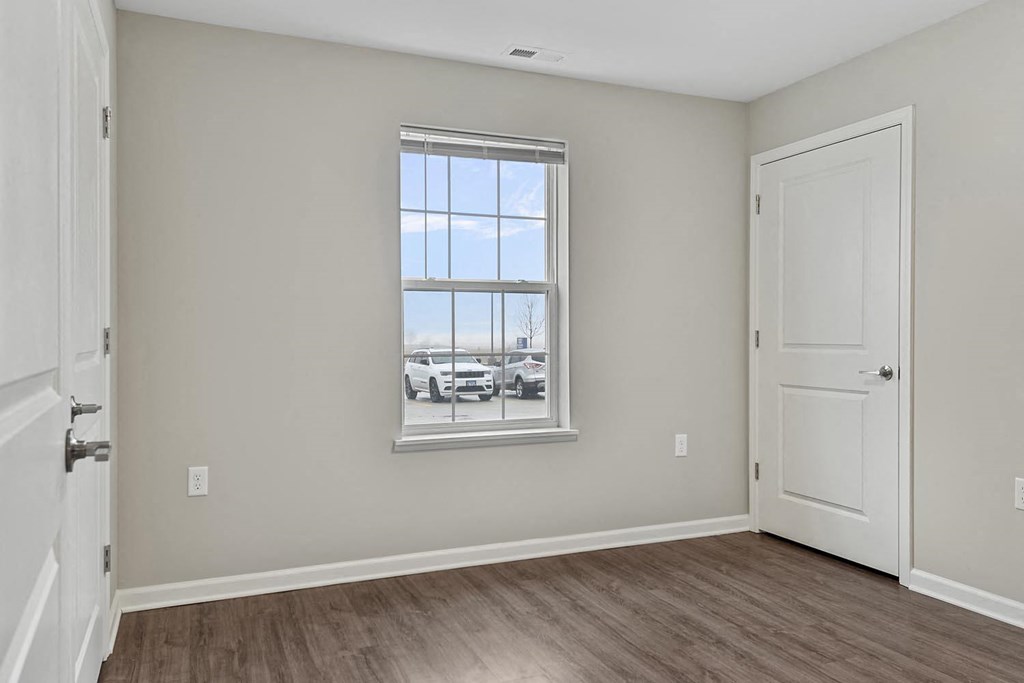 an empty living room with a window and a door