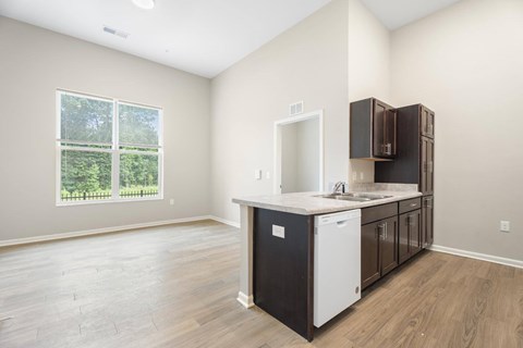 A kitchen with a white dishwasher and wooden cabinets.