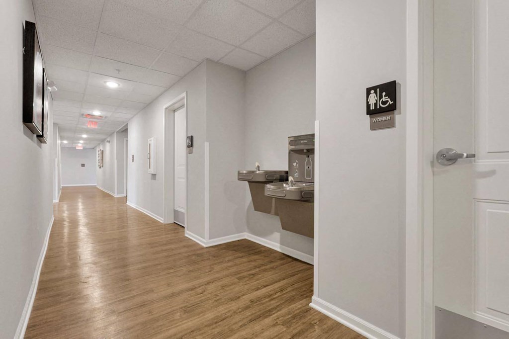 a long hallway with white walls and wood floors