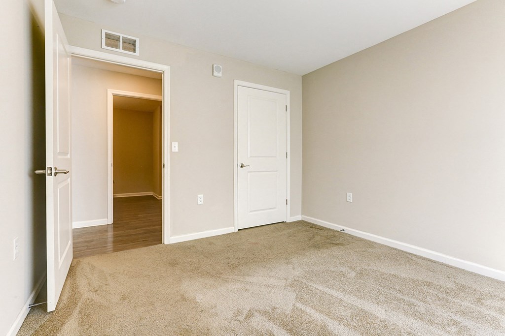 an empty living room with a door open to a hallway