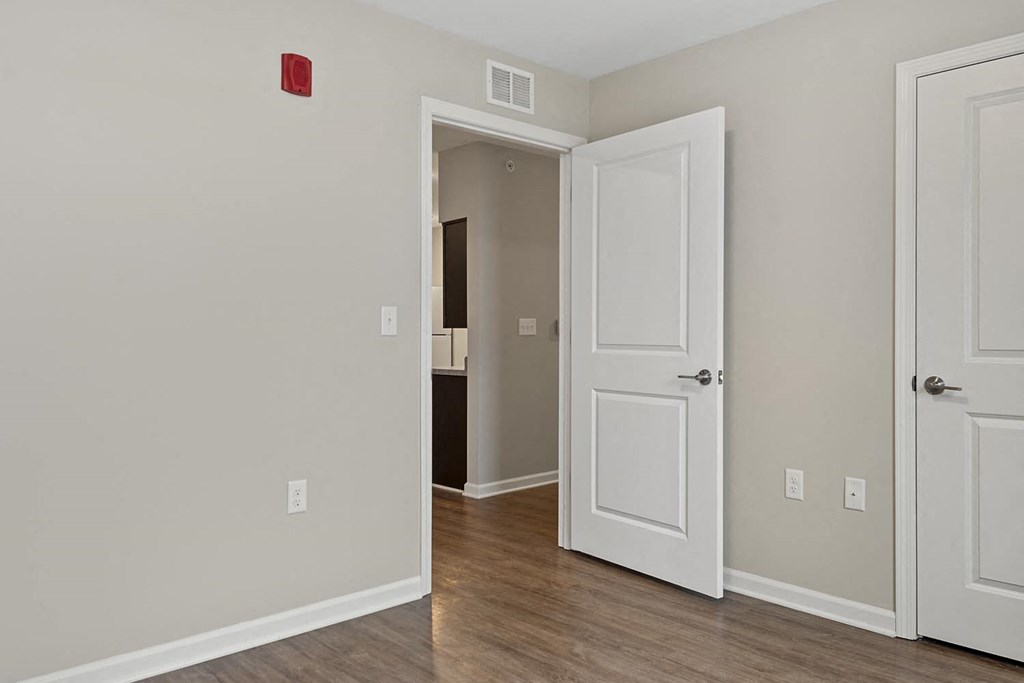 a bedroom with a door open and a hallway to a bathroom