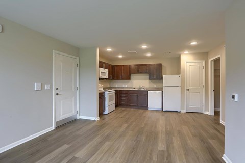 A kitchen with white appliances and wooden floors.