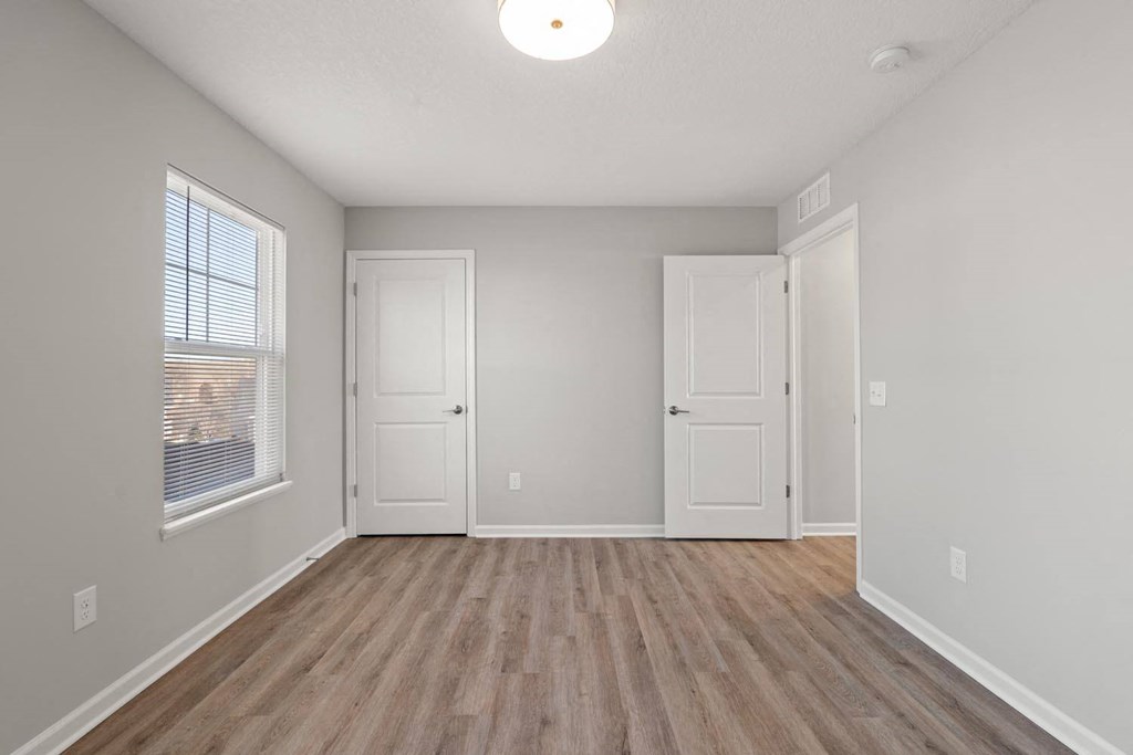 A room with wooden flooring and white walls.