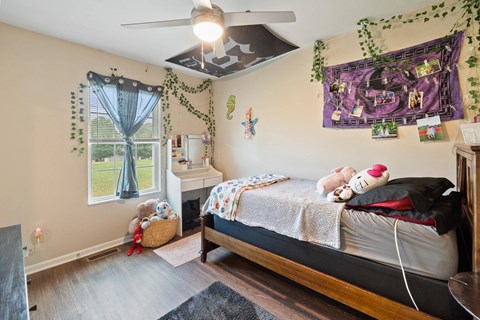 a bedroom with a bed and a ceiling fan
