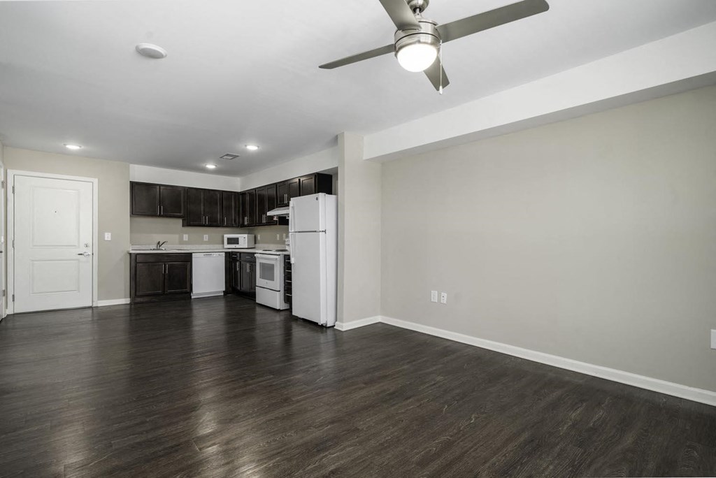 a renovated living room and kitchen with a ceiling fan