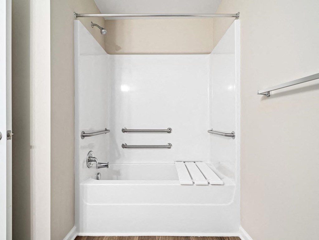 a white bathroom with a tub and a towel rack