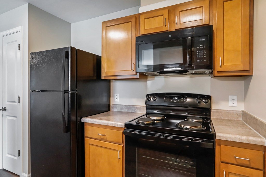 a kitchen with wood cabinets and black appliances
