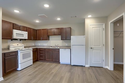A kitchen with brown cabinets and white appliances.