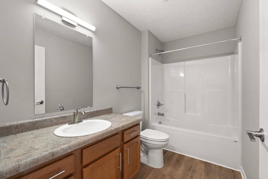 A bathroom with a sink, toilet, and shower.