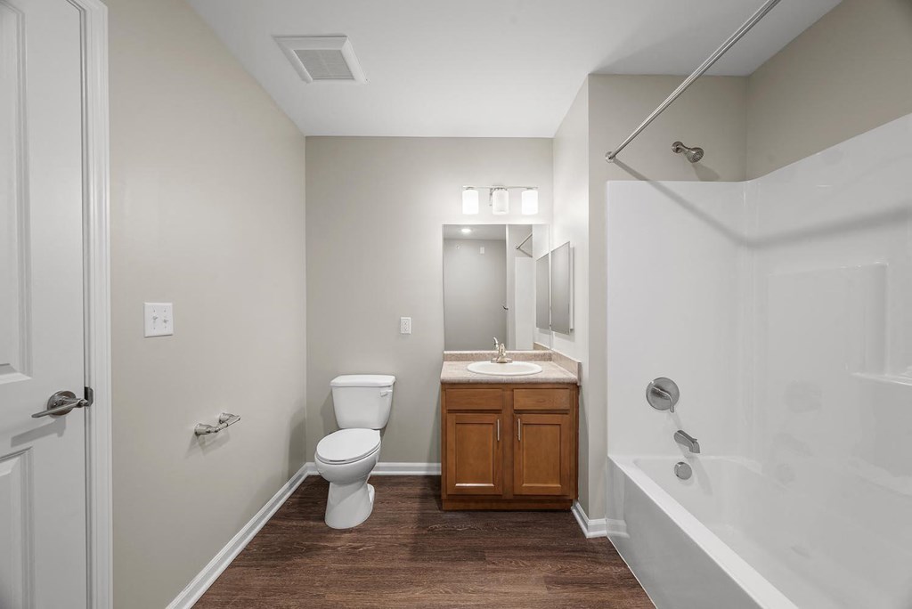 A bathroom with a toilet, sink, and bathtub.