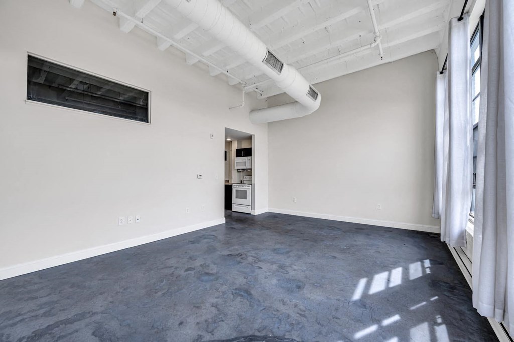 an empty room with white walls and a large window