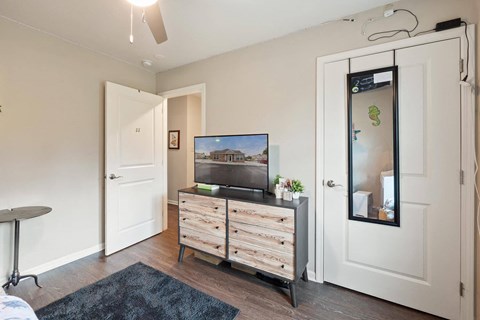 a bedroom with a tv and a dresser