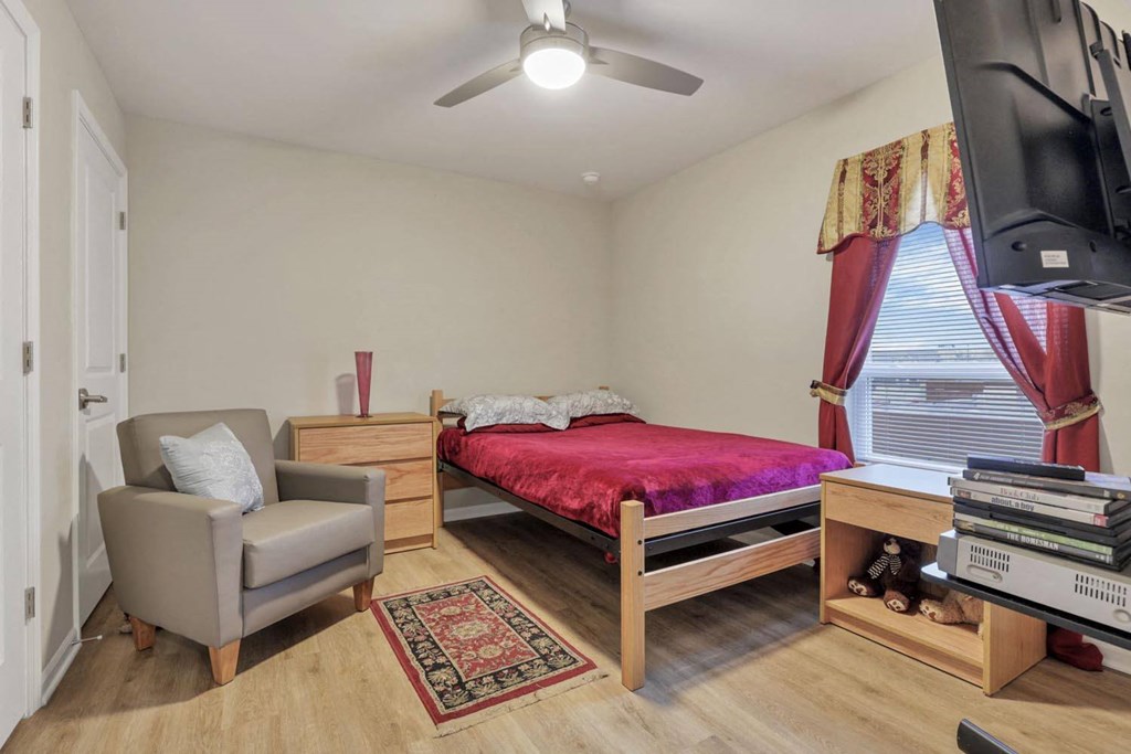 a bedroom with a bed and a ceiling fan