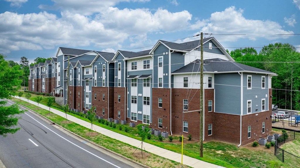 an aerial view of a row of apartment buildings next to a street