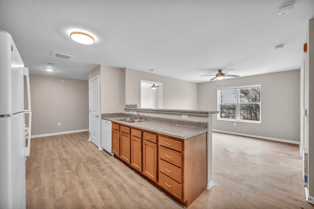 an empty kitchen with a refrigerator and a sink