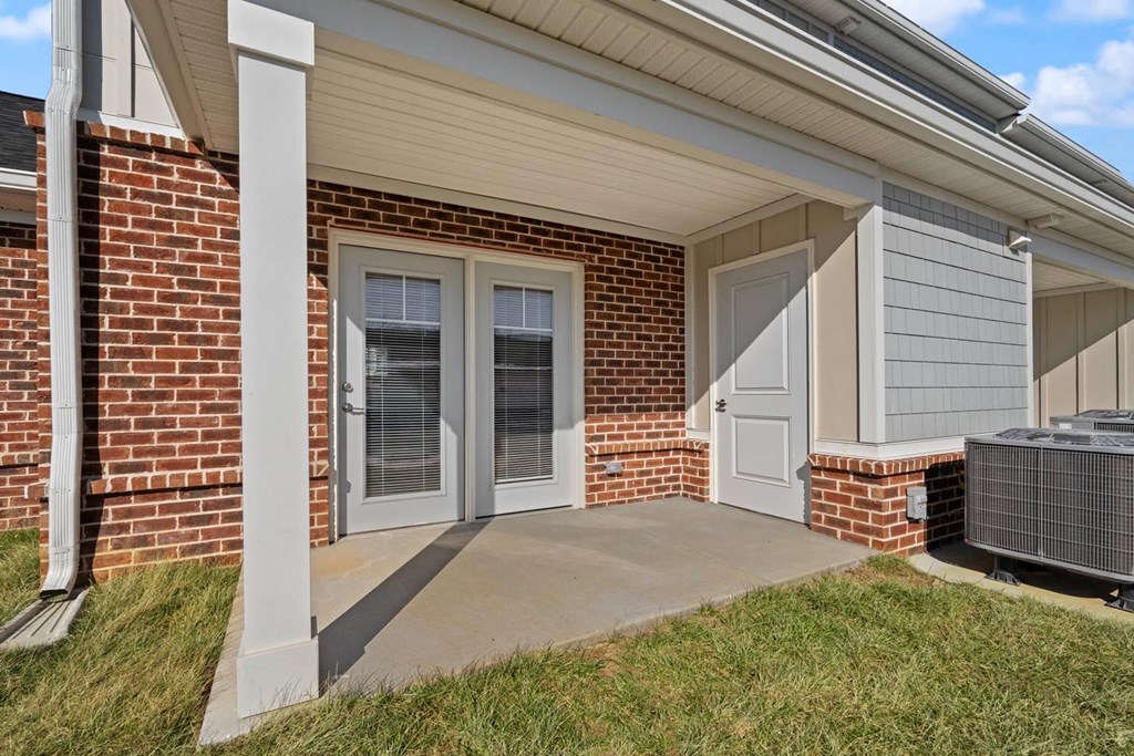 A house with a brick wall and a white door.