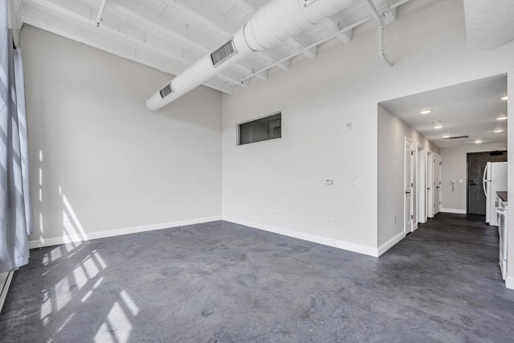 a large room with white walls and a concrete floor