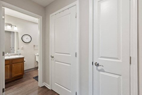 a bathroom with white doors and a sink and a mirror