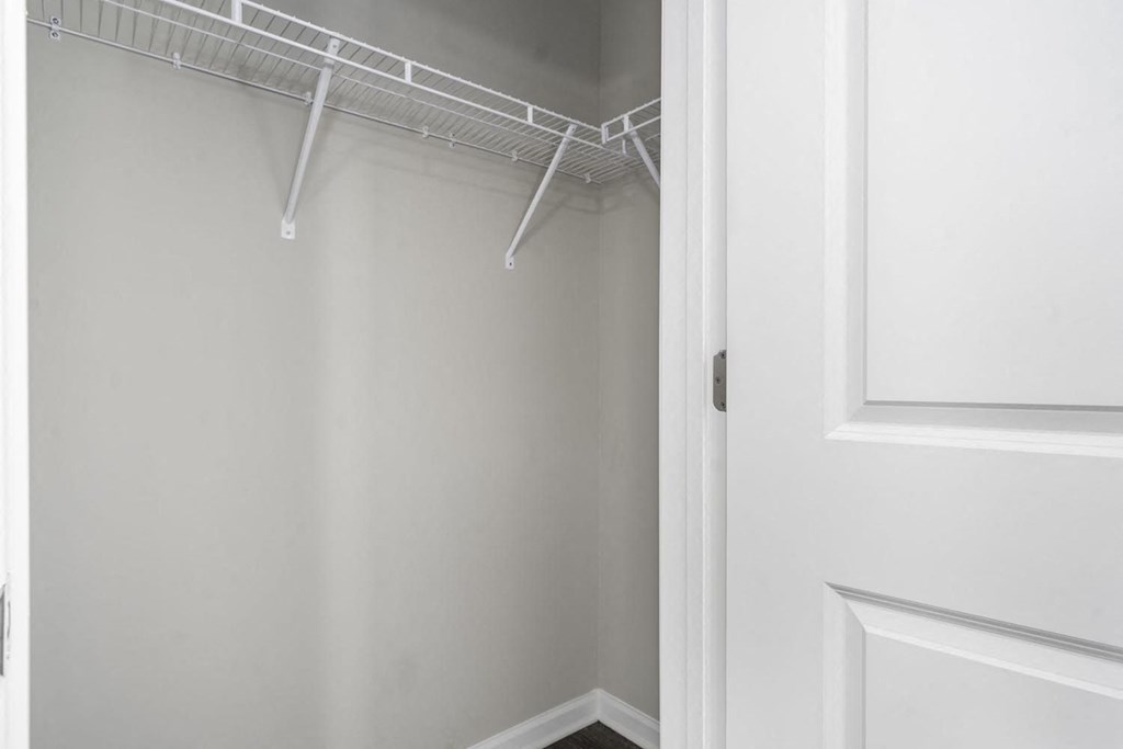 a walk in closet with white walls and a white door