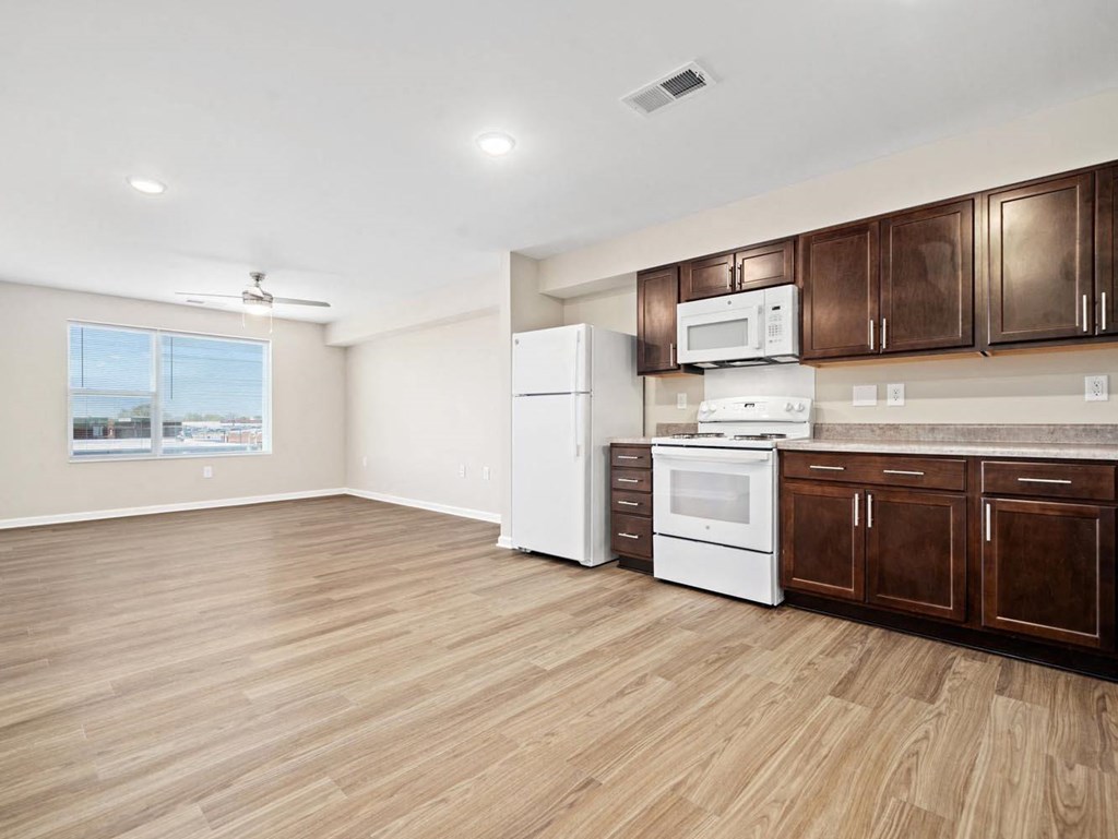 an empty kitchen with a microwave and a refrigerator
