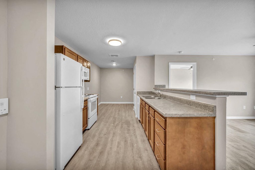 an empty kitchen with a refrigerator and a sink