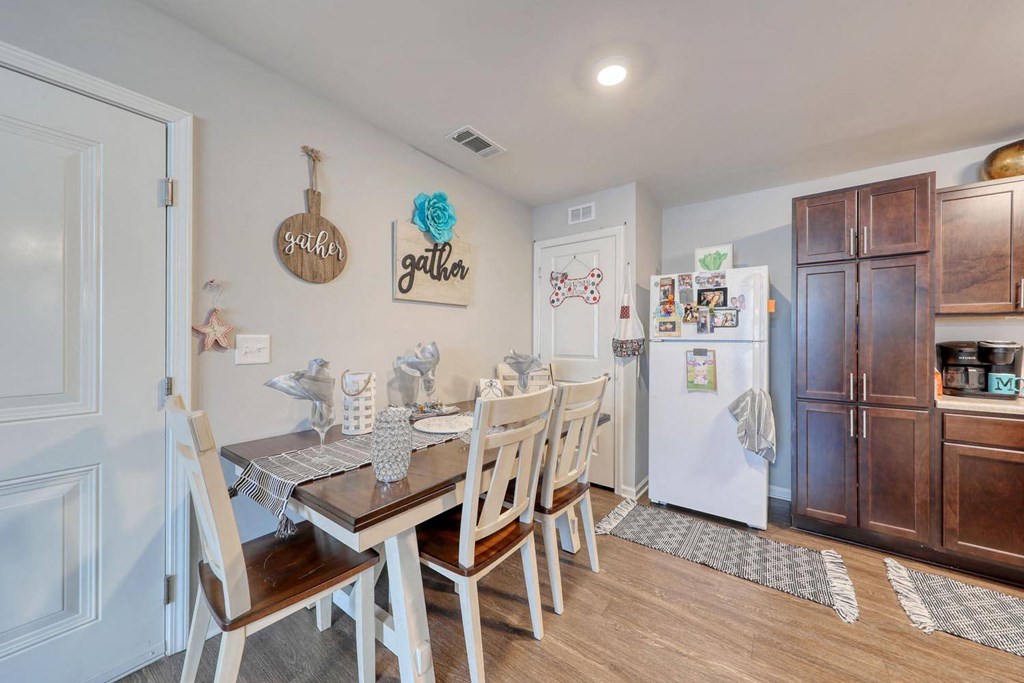 a dining room with a table and chairs next to a kitchen
