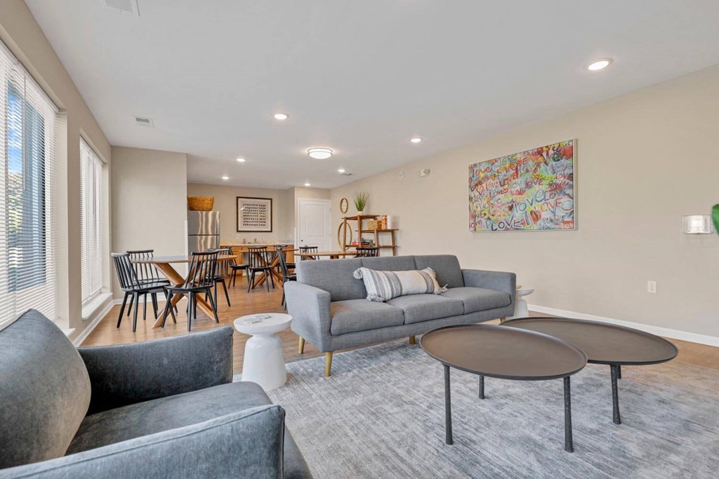 a living room with couches and chairs and a dining room table