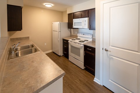 a kitchen with white appliances and a sink and a refrigerator
