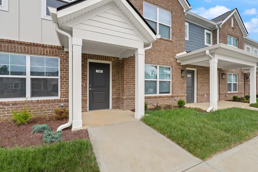 A house with a black front door and a white porch.