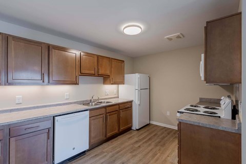 A kitchen with wooden cabinets and a white fridge.