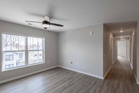 A spacious room with a ceiling fan and a long hallway.