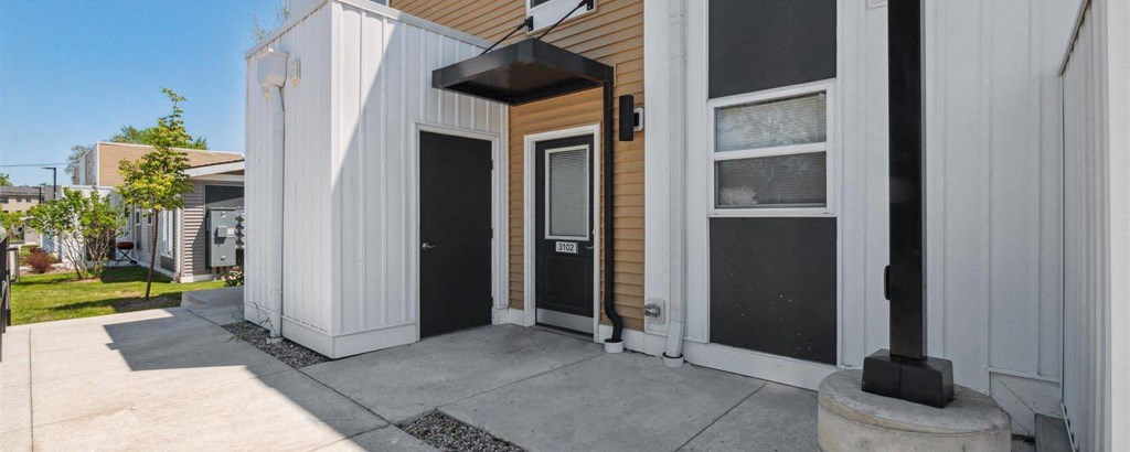 the front of a building with two black doors