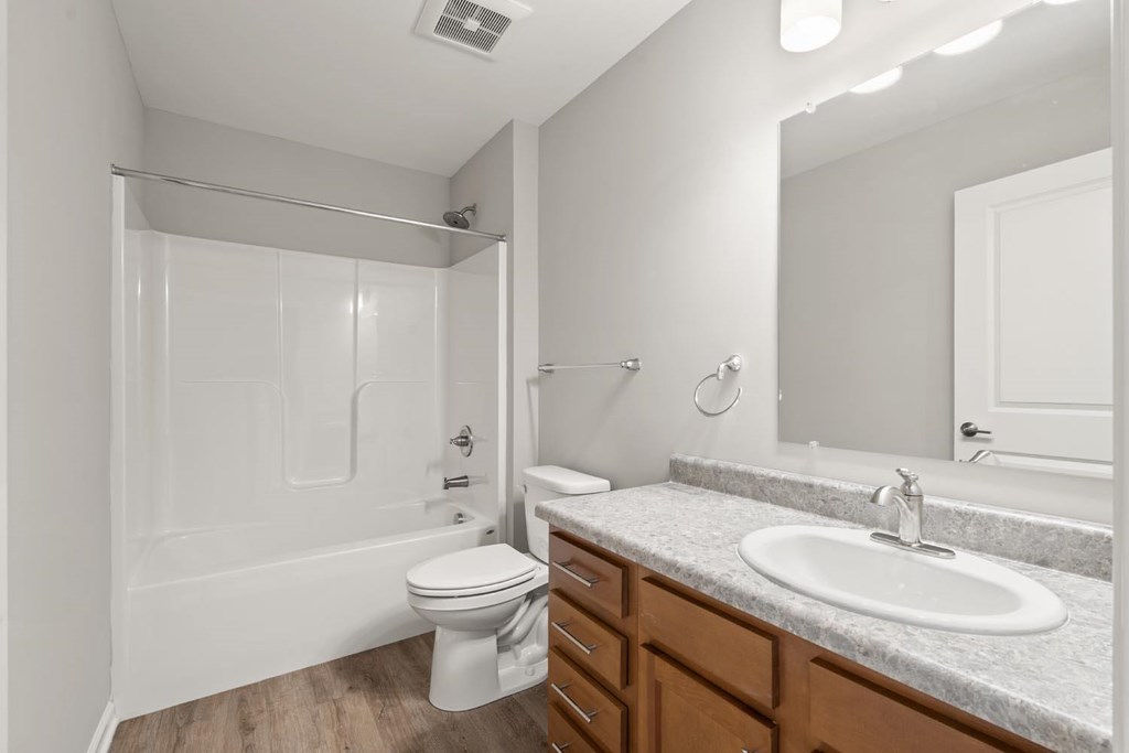 A white bathroom with a toilet, sink, and shower.