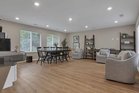 A living room with a wooden floor and a large window.