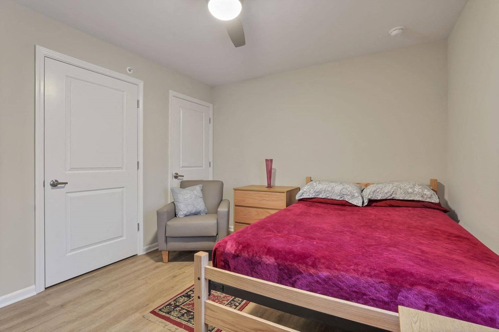 a bedroom with a bed and a chair and a closet