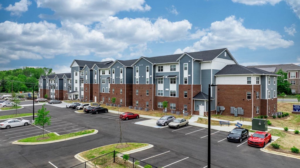 an empty parking lot in front of an apartment building
