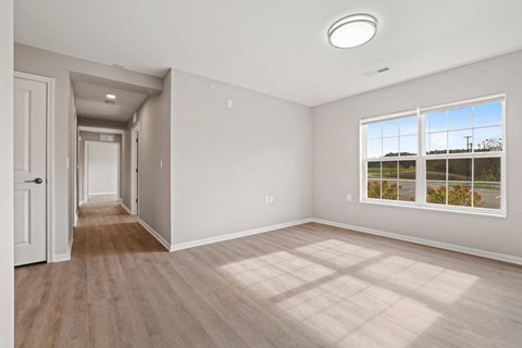 an empty living room with a door to a hallway